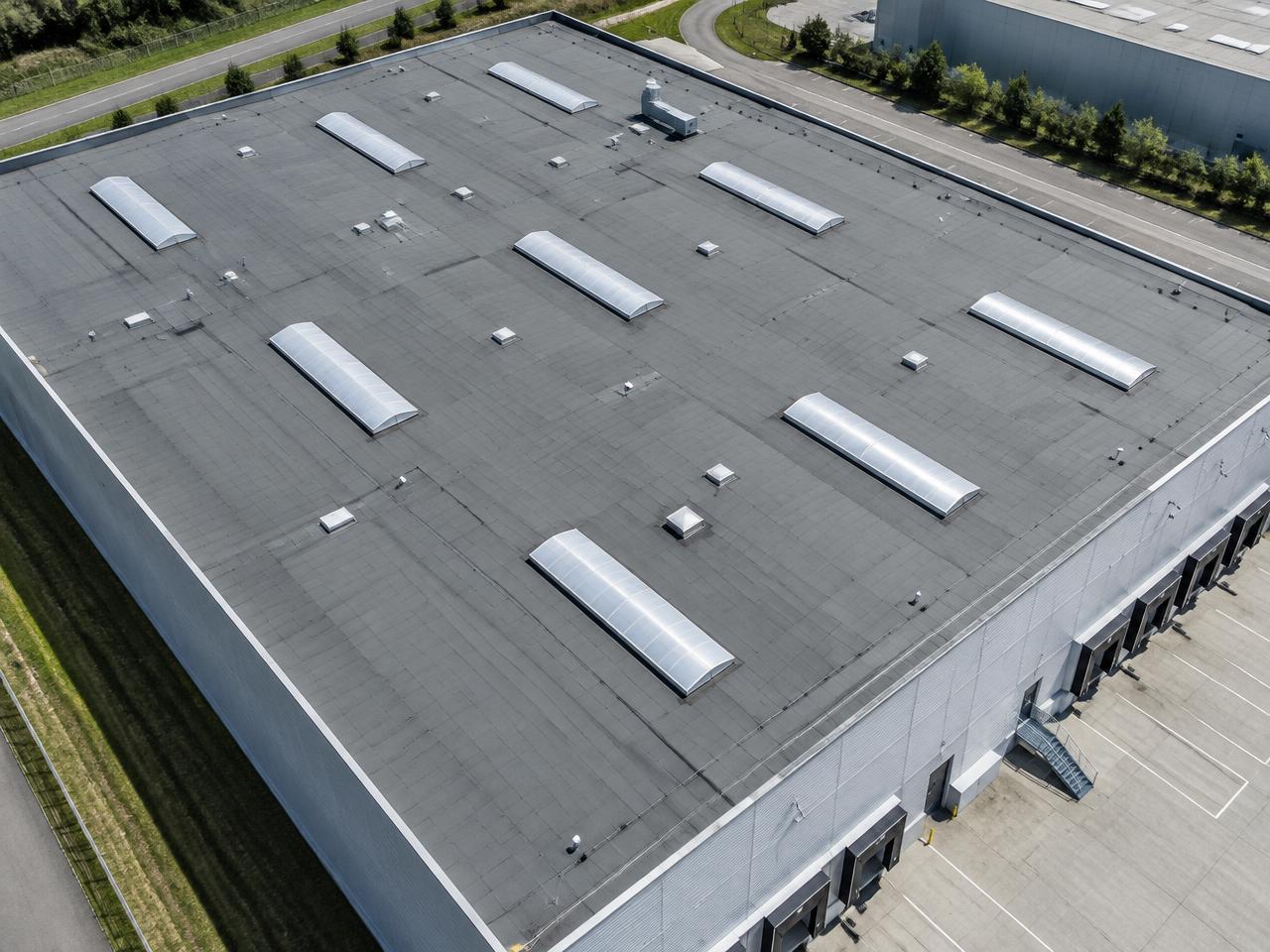 Gewerbliches Flachdach einer Lagerhalle aus der Luft